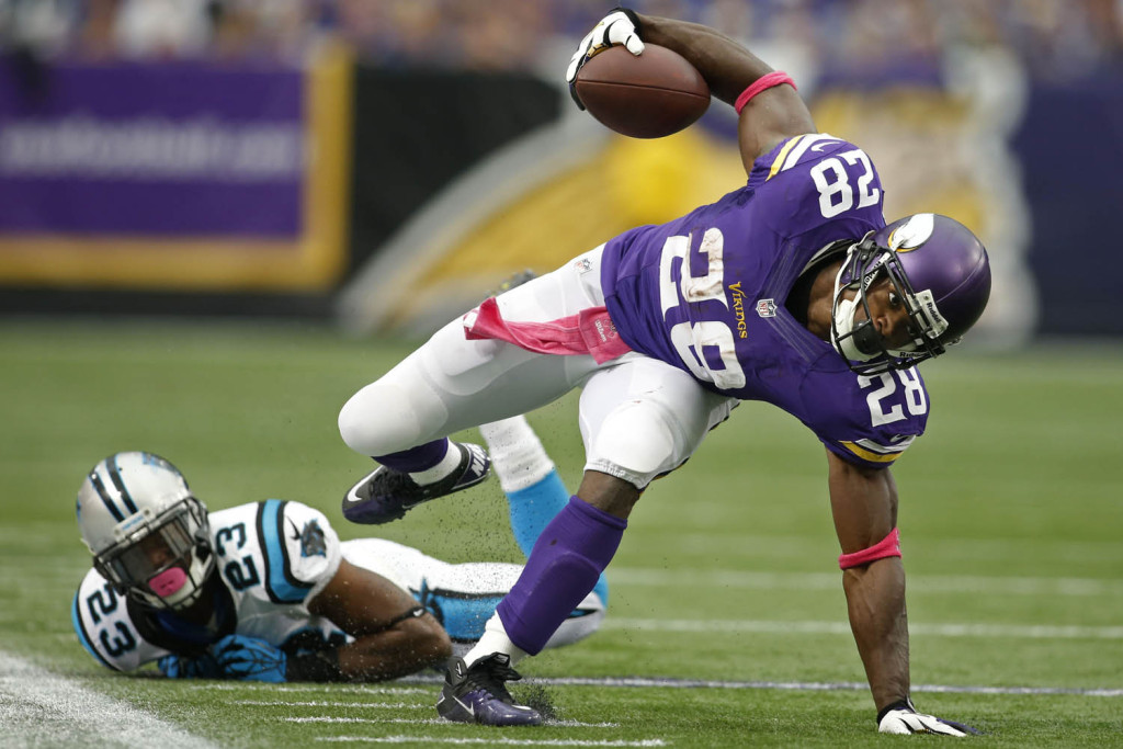 Oct 13, 2013; Minneapolis, MN, USA; Minnesota Vikings running back Adrian Peterson (28) breaks the tackle of Carolina Panthers cornerback Melvin White (23) in the second quarter at Mall of America Field at H.H.H. Metrodome. Panthers win 35-10. Mandatory Credit: Bruce Kluckhohn-USA TODAY Sports
